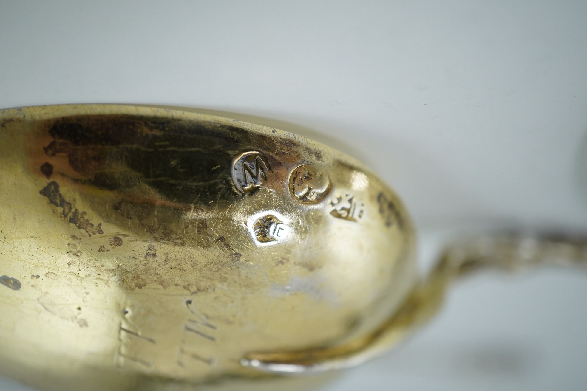 An early 17th century Dutch silver gilt spoon with galleon ship terminal, 18cm and two Victorian silver apostle spoons, Sheffield 1900, 17.5cm, 142g gross. Condition - fair